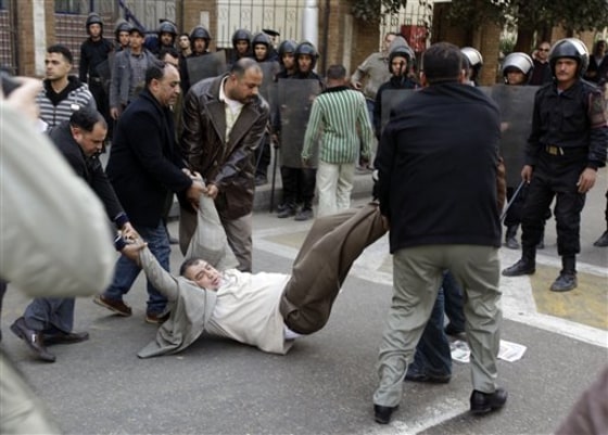 Egyptian plainclothes policemen arrest a man outside the Press Syndicate Council, a journalists union, in downtown Cairo Wednesday.